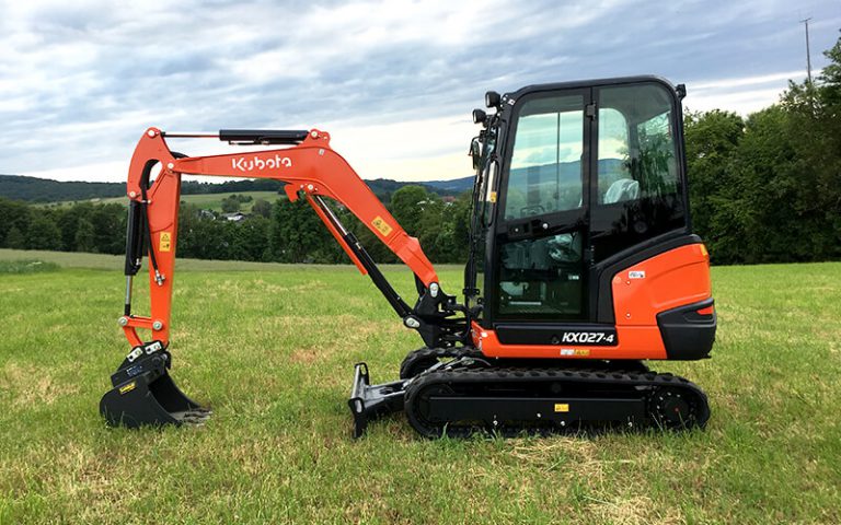 Minibagger KX027-4 steht auf einer grünen Wiese